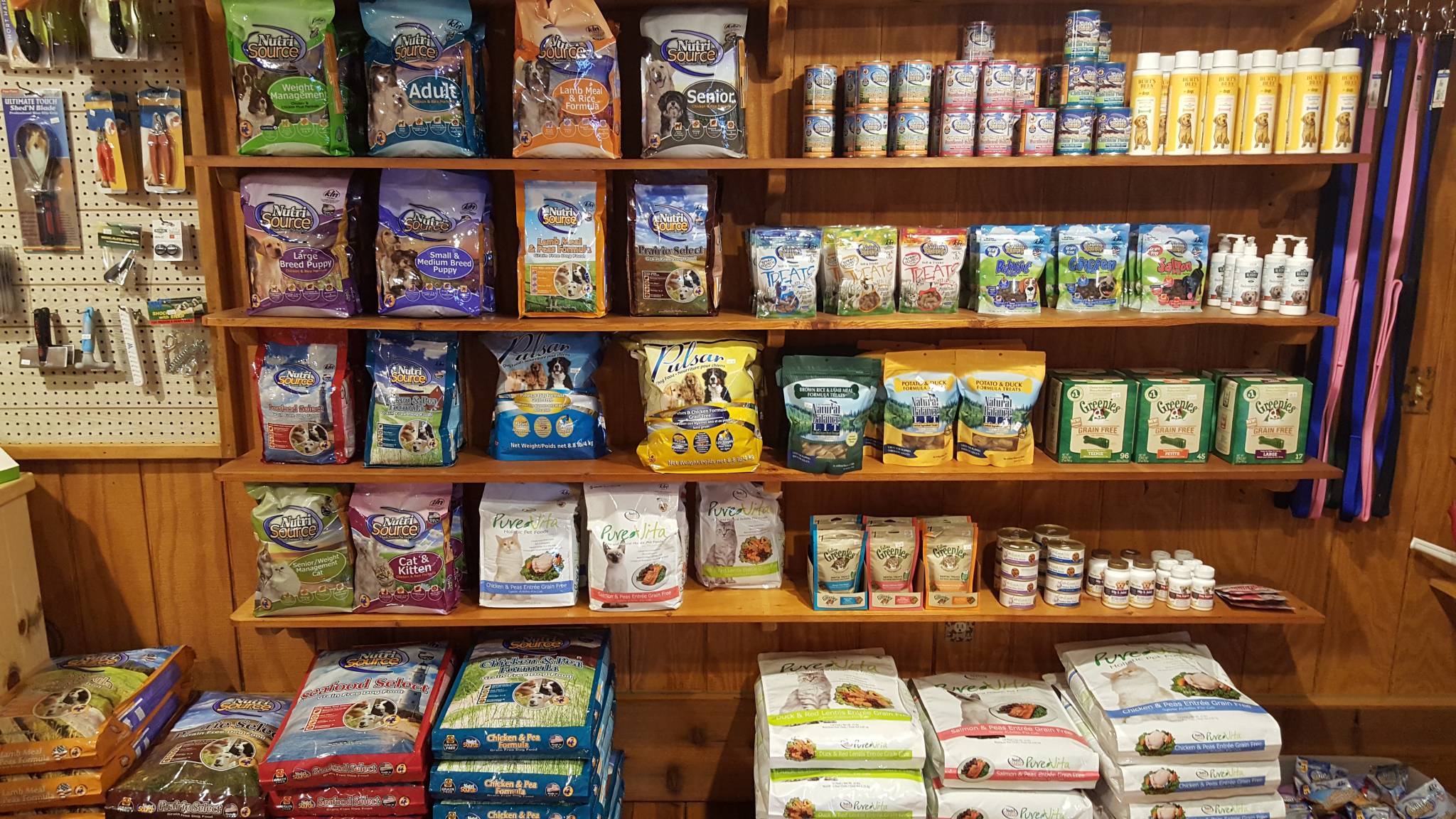 Вигляд магазину з широким асортиментом корму для собак та котів на полицях.
